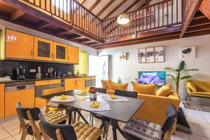 a kitchen and living room with a table and a couch at VILLA DALHIA in Pointe-Noire