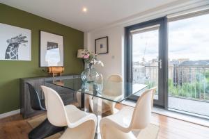 a dining room with a glass table and chairs at SECC Hydro Executive 7 Apartment in Glasgow