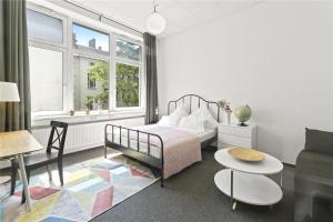 1 dormitorio con cama, mesa y sofá en Holiday 33 Apartments ABCD Alexanderplatz, en Berlín