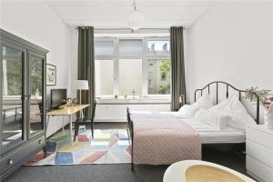 Schlafzimmer mit einem Bett, einem Schreibtisch und einem Fenster in der Unterkunft Holiday 33 Apartments ABCD Alexanderplatz in Berlin