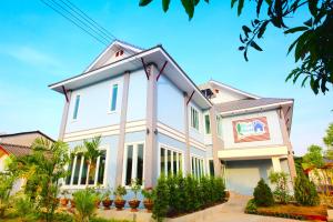 a white house with a gambrel roof at Blue House Sukhothai in Sukhothai