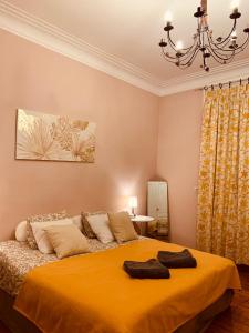 - une chambre dotée d'un lit avec des draps jaunes et un lustre dans l'établissement Bijou Brussels > Parvis St Pierre, à Bruxelles
