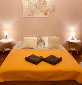- une chambre avec un grand lit jaune et deux lampes dans l'établissement Bijou Brussels > Parvis St Pierre, à Bruxelles
