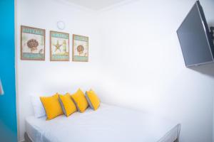 a bedroom with a bed with yellow pillows and a tv at Cristal Caribbean Rodadero Santa Marta in Santa Marta