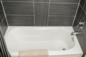 a white bath tub in a bathroom with tiles at Crescent Motel in Radium Hot Springs