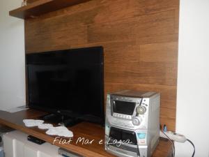 un ordenador y un monitor sobre una mesa de madera en Flat entre Mar e Lagoa, en Arraial do Cabo