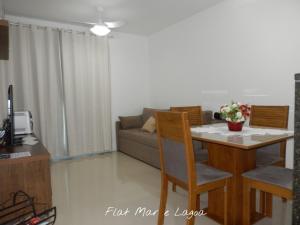 sala de estar con mesa y sofá en Flat entre Mar e Lagoa en Arraial do Cabo