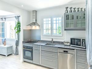 a kitchen with a sink and a microwave at Holiday home in La Roquette sur Siane in La Roquette-sur-Siagne