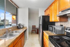 cocina con fregadero y microondas en Waikiki Beach Condominiums en Honolulu
