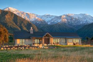 a house with mountains in the background at Manakau Lodge in Kaikoura