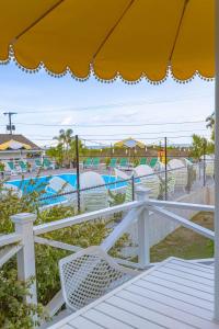 a deck with white chairs and a swimming pool at RYE MOTOR INN - An Adults Only Hotel in Rye