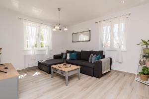 salon z czarną kanapą i stołem w obiekcie Villa St Vid 1 w mieście Privlaka