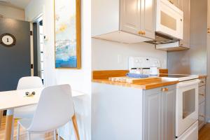 cocina con armarios blancos, mesa y sillas en GREAT ISLAND INN - A Modern Boutique Hotel, en New Castle