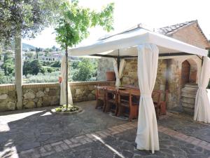 una sombrilla blanca en un patio con mesa en Belvilla by OYO Casa del Re, en Le Piazze