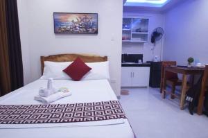 a bedroom with a bed and a table in it at Sea Garden Suites in Dauis
