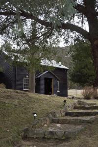 une vieille maison avec deux oiseaux debout devant elle dans l'établissement Crackenback Farm Guesthouse, à Crackenback