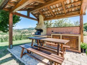 a picnic table under a pavilion with an outdoor oven at Belvilla by OYO Sant Angiolino in Urbania