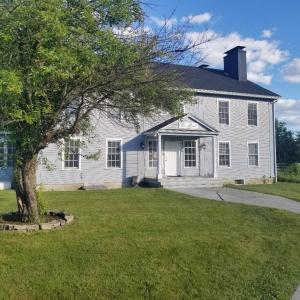 una casa blanca con un árbol en el patio en The Bond 1786 Inn, en Warrensburg