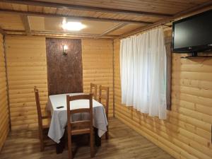 ein kleines Esszimmer mit einem Tisch und einem TV in der Unterkunft Шепіт річки in Synewyr