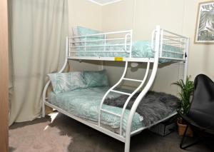 2 Etagenbetten in einem Zimmer mit einem Sofa in der Unterkunft Investigator Beach Breeze Apartments U3 in Kingscote
