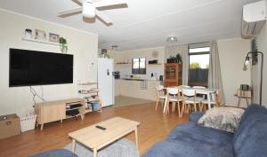 een woonkamer met een blauwe bank en een tafel bij Investigator Beach Breeze Apartments U3 in Kingscote