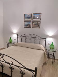una camera da letto con un letto con due tavoli con vasi verdi di Donna Filomena a Monopoli