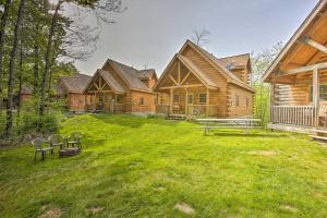 a log house with a yard with a bench in front of it at Resort Cabin with Fire Pit Golf, Hike and Play! in Rothbury