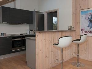 a kitchen with two white chairs and a counter at 6 person holiday home in Ebeltoft in Ebeltoft