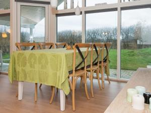 a dining room with a green table and chairs at 6 person holiday home in Ebeltoft in Ebeltoft