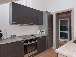 a kitchen with brown cabinets and a stove top oven at 6 person holiday home in Ebeltoft in Ebeltoft