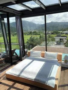 a bedroom with a bed and a large window at Aqua Star Villa Homestay in Dongshan