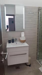 a bathroom with a white sink and a mirror at AURA Residence in Rovinj