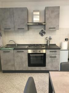 een keuken met een roestvrijstalen fornuis top oven bij Appartamento sulla piazza 90 m dal mare in Anzio