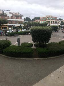 een park met een standbeeld en struiken en gebouwen bij Appartamento sulla piazza 90 m dal mare in Anzio