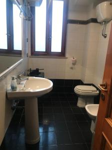 een badkamer met een wastafel en een toilet bij Appartamento sulla piazza 90 m dal mare in Anzio