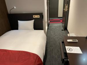 una camera d'albergo con letto e scrivania di Ai Hotel Keikyu Kamata-ekimae a Tokyo