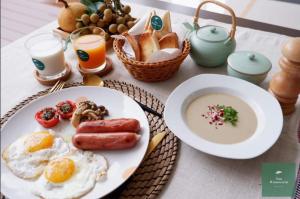 Ban Tong的住宿－น่านวรรณวัตร รีสอร์ท Nan Wannawat Resort，一张桌子,上面有一盘早餐食品和饮料