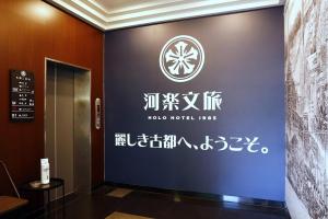 a sign on the wall of a hotel lobby at Holo Hotel Tainan in Tainan +24 photos