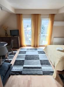een slaapkamer met een bed en een geruit tapijt bij NAPKŐ APARTMAN in Sopron