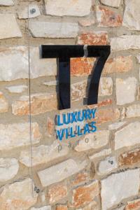 uma parede de pedra com um número nela em T7 LUXURY VILLAS PAROS em Kampos Paros