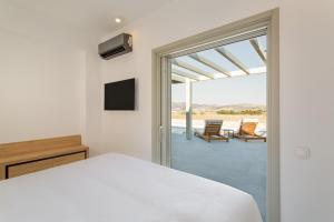 カンポスにあるT7 LUXURY VILLAS PAROSのベッドルーム1室(ベッド1台付)、バルコニー(椅子付)