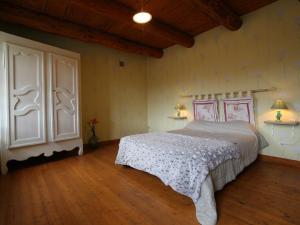 een slaapkamer met een bed en een houten vloer bij Gîte Saint-Paulien, 4 pièces, 6 personnes - FR-1-582-266 in Saint-Paulien
