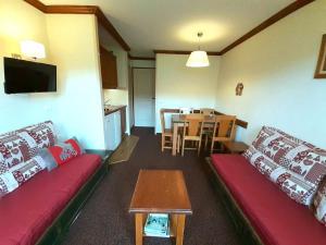 ein Wohnzimmer mit zwei roten Sofas und einem Tisch in der Unterkunft Appartement Plagne Soleil, 2 pièces, 5 personnes - FR-1-351-89 in Plagne Villages