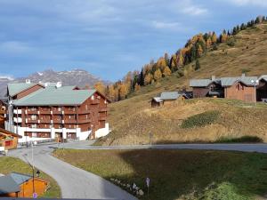 Plagne VillagesにあるAppartement Plagne Soleil, 2 pièces, 5 personnes - FR-1-351-89の道路横の丘の上の建物