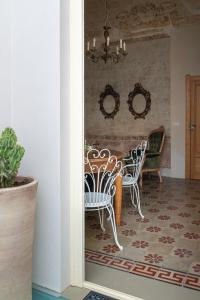 uma sala de jantar com duas cadeiras e uma mesa em Boudoir degli Orti, Unconventional Stay in Borgata, Siracusa em Siracusa