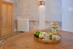 a table with a tray of fruit and glasses on it at Boudoir degli Orti, Unconventional Stay in Borgata, Siracusa in Siracusa +30 photos