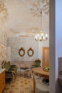 uma sala de estar com uma mesa e cadeiras e um tecto em Boudoir degli Orti, Unconventional Stay in Borgata, Siracusa em Siracusa