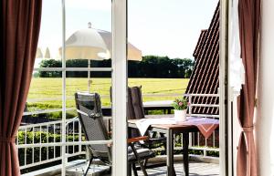 een balkon met een tafel en stoelen en uitzicht op een veld bij Gästehaus Sam in Bad Sassendorf