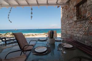 een eettafel met uitzicht op het strand bij Kyanis Villa , Karpathos Afiartis in Afiartis