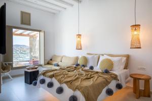 a bedroom with a large bed and a couch at Due Mari Mykonos in Agios Ioannis Mykonos